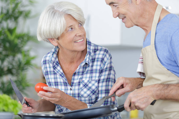 Seniorenpaar bereitet Essen in der Küche zu - Foto, Bild