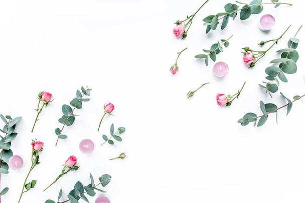 Floral pattern made of pink roses, green leaves eucalyptus, branches on white background. Flat lay, top view. Valentines background. Floral pattern. - Foto, imagen