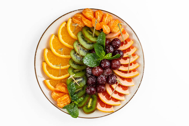 cutted fruits plate on white plate on background - Foto, afbeelding