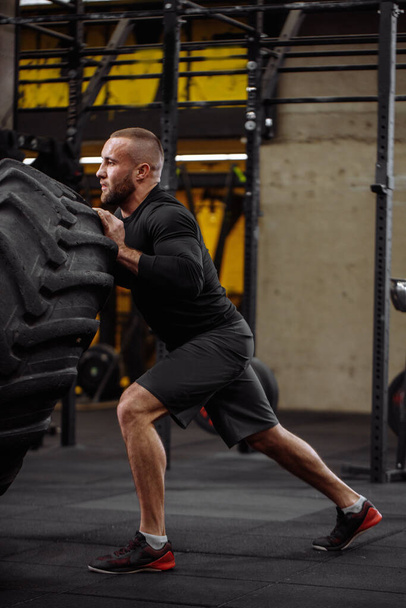 bodybuilding trainings with a tire. guy leads healthy lifestyle - Photo, Image