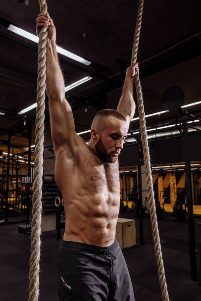 tired exhausted fit guy is hanging on sport equipment - Фото, изображение