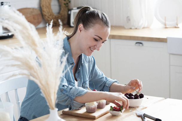 young woman pastry chef decorates cupcakes - Foto, Imagem