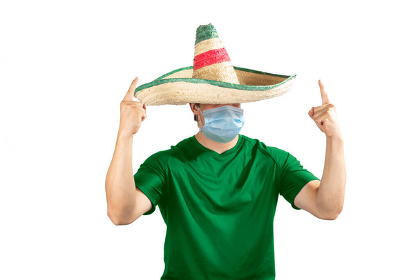 Mexicano com uma camisa de futebol verde e uma máscara com um grito de excitação para feriados nacionais. - Foto, Imagem