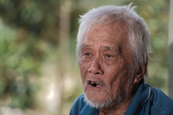 E velho fazendeiro estava descansando em uma cabana no pomar duriano. - Foto, Imagem