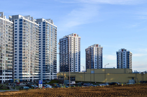 blauwe grote glazen huizen in het centrum. hoge woongebouwen voor mensen, moderne gebouwen. in het centrum is er een uniek beige winkelcentrum. stedelijk landschap - Foto, afbeelding
