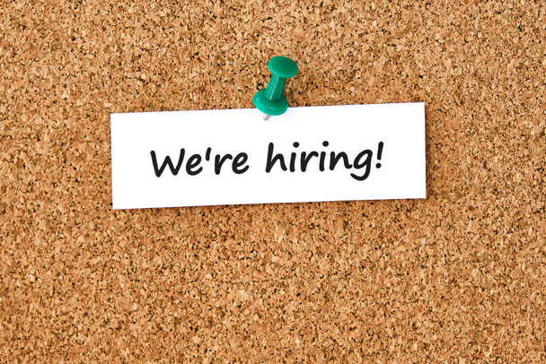 We're hiring. Text written on a piece of paper or note, cork board background. - Photo, Image