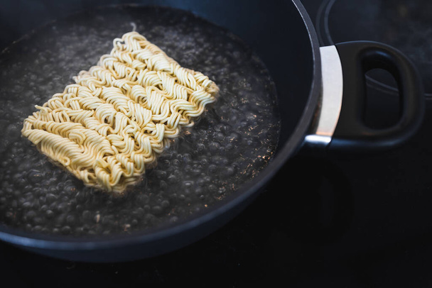 simple food ingredients concept, noodles cooking in pan on kitchen stove top - Zdjęcie, obraz
