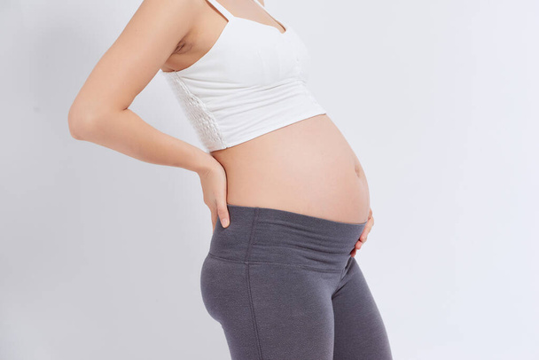 Une femme enceinte ressent la douleur. Elle a mal au dos. Une femme enceinte à la maison. Stress pendant la grossesse. - Photo, image