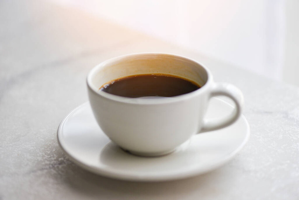 чашка кофе на столе / черный кофе в белой кружке на столе - Фото, изображение