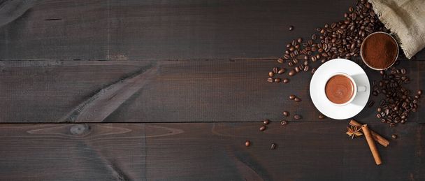 Coffee in a white cup and coffee beans on the table. Top view. Dark background. - Fotografie, Obrázek