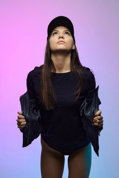 girl in a black jacket and cap in the Studio. - Фото, изображение