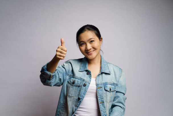 Asiática mujer feliz mostrando pulgar hacia arriba de pie aislado sobre fondo blanco. - Foto, Imagen