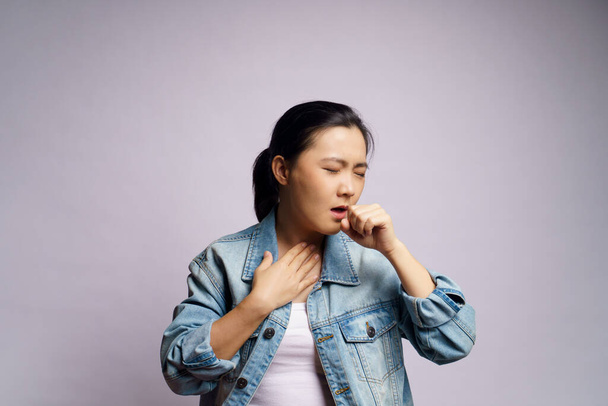 Aziatische vrouw was ziek van koorts, hoesten niezen en staan geïsoleerd op witte achtergrond. - Foto, afbeelding
