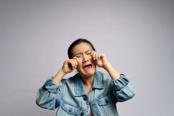 aziatische vrouw verdrietig en huilen staande geïsoleerd op witte achtergrond. - Foto, afbeelding