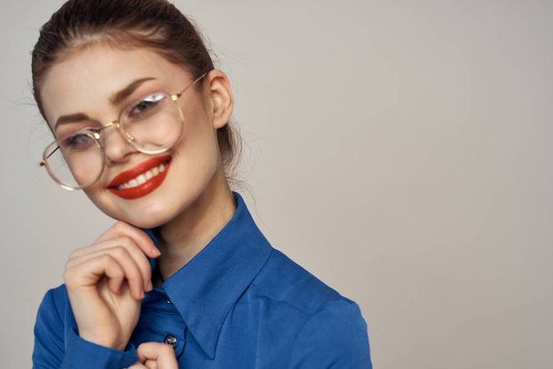 Portrait of emotional woman in blue shirt and glasses bright makeup model light background cropped view Copy Space - Фото, зображення