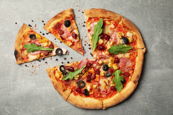 Lekker vlees pizza op grijze achtergrond, bovenaanzicht - Foto, afbeelding