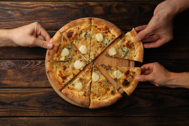 Χέρια κρατήσει φέτες νόστιμο πίτσα τυρί, πάνω άποψη - Φωτογραφία, εικόνα
