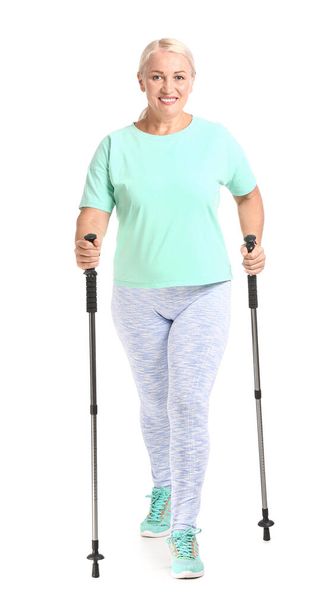 Donna matura con bastoni da passeggio su sfondo bianco - Foto, immagini