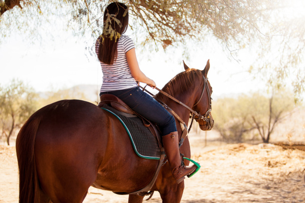 Женщина верхом на лошади и смотрит вперед
 - Фото, изображение