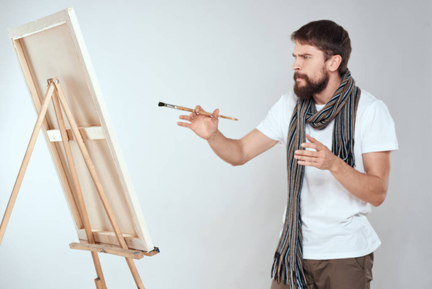 Чоловік художник малює на мольберті шарф біла футболка творчість хобі
 - Фото, зображення