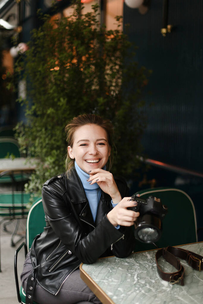 若いです幸せな女性座ってストリートカフェとともにカメラ. - 写真・画像