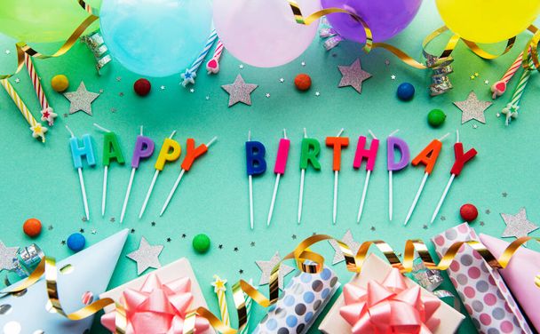 Texte Joyeux anniversaire par lettres de bougie avec asseccories anniversaire, bougies et confettis sur fond vert pastel - Photo, image