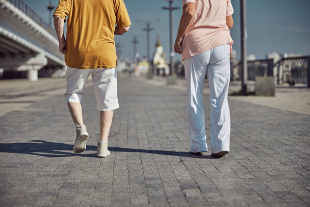 Senior Caucasian couple practicing brisk walking outdoors - Foto, imagen