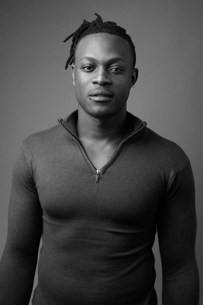 スタジオショットの若いですハンサムなアフリカ人男性でケニアから灰色の背景に黒と白 - 写真・画像