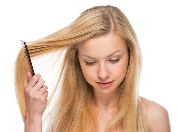 Young woman combing hair - Фото, зображення
