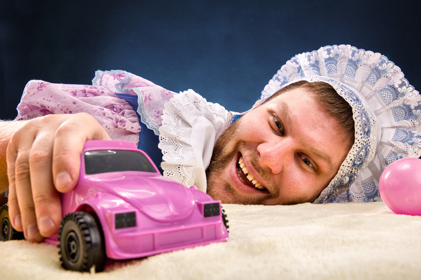 Hombre vestido de bebé con coche
 - Foto, imagen