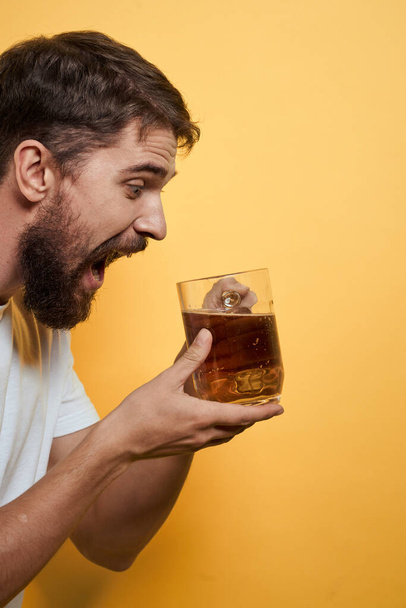 Férfi egy bögre sör szórakoztató alkohol életmód fehér póló sárga elszigetelt háttér - Fotó, kép