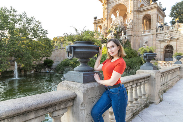 Una donna bionda in posa con una pianta al Citadel Park di Barcellona - Foto, immagini