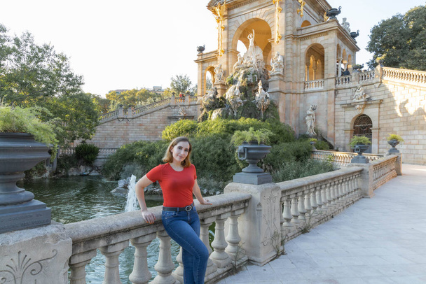 A blonde woman with red t-shirt in a fountain at Citadel Park in Barcelona - Фото, зображення
