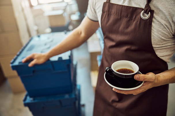 Muž pracovník ruka drží černý šálek kávy - Fotografie, Obrázek