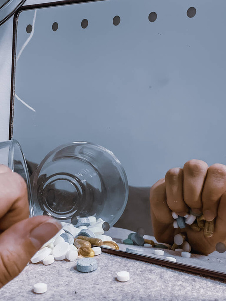 A vertical shot of a person holding medicine pills - drug addiction concept - Zdjęcie, obraz