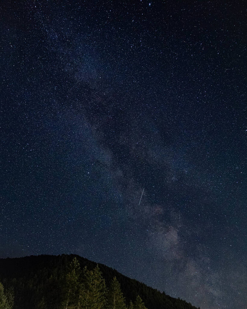 A vertical shot of a hill under a starry sky at night - perfect for wallpapers - 写真・画像