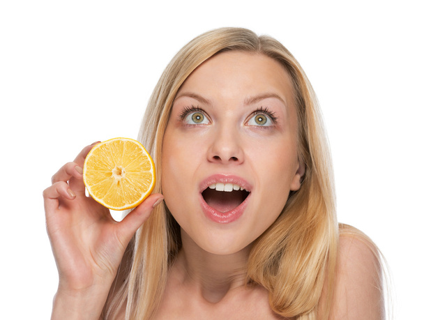 Portrait of surprised young woman with lemon looking on copy spa - Photo, image