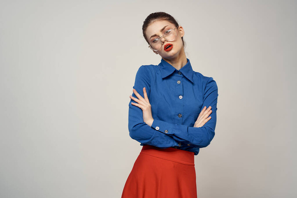 woman model in blue shirt and red skirt glasses beautiful face makeup studio - Foto, afbeelding