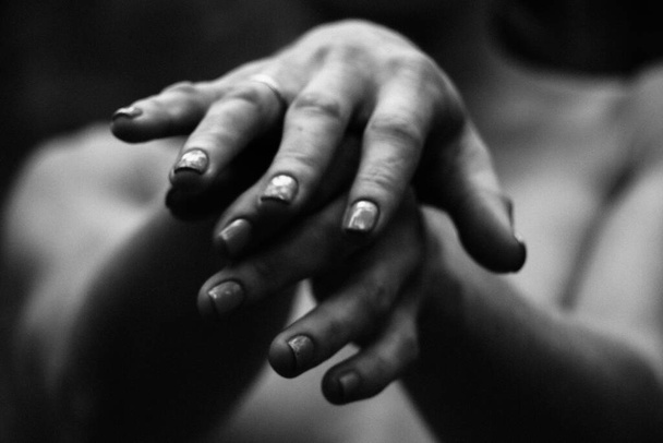 Close-up graceful pose of a beautiful woman's hands black and white photo, on the background of a naked body, back shoulders, simple and natural pose. - Фото, изображение