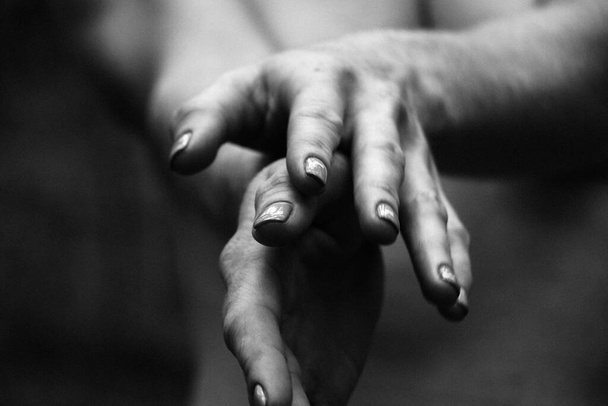 Close-up graceful pose of a beautiful woman's hands black and white photo, on the background of a naked body, back shoulders, simple and natural pose. - Фото, зображення