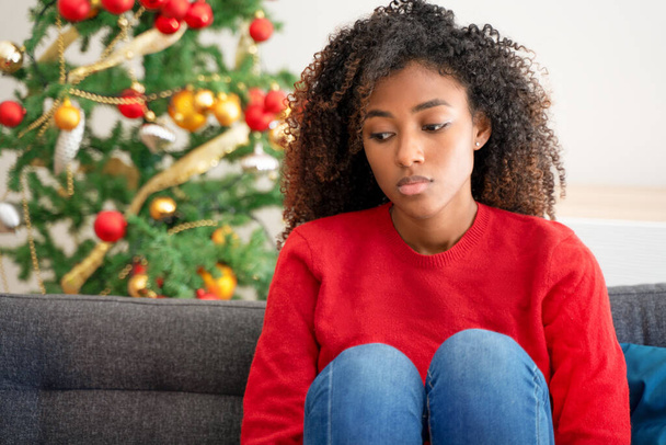Besorgte schwarze junge Frau im Weihnachtsurlaub zu Hause - Foto, Bild