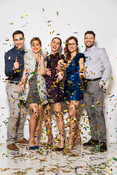 happy friends at party under confetti over white - Foto, Bild