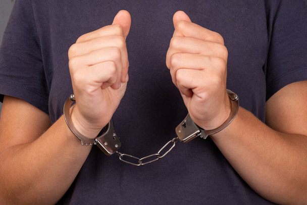 arrestatie voor aanranding, man in handboeien close up - Foto, afbeelding