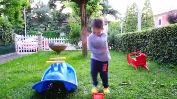 bellissimo bambino gioca e balla in giardino. Filmati FullHD di alta qualità - Filmati, video