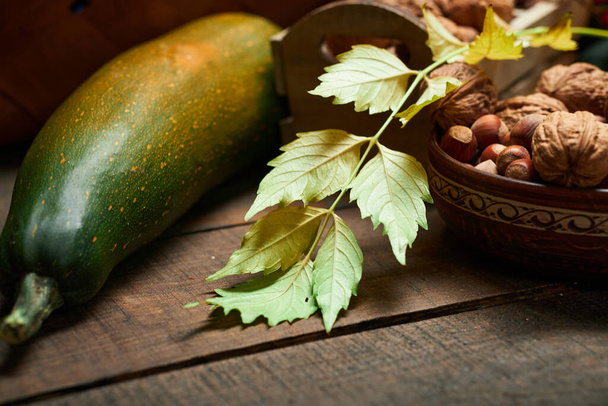 herfst stilleven in rustieke stijl als achtergrond - bladeren, groenten en fruit, noten en andere natuurlijke voedselingrediënten op houten planken - Foto, afbeelding