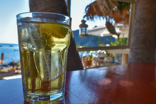 Alcoholic drink resting on a table in a tropical beach bar. - Photo, Image
