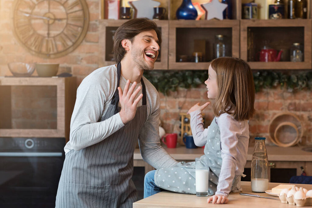 Mutfak eğlencesi. Genç Baba ve küçük kızı birlikte yemek pişirirken gülüyorlar. - Fotoğraf, Görsel