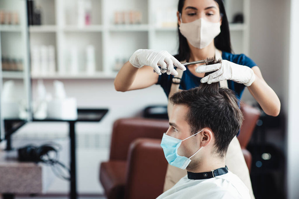 男性のクライアントの美容師切断髪の閉じる予防措置、空のスペースを観察 - 写真・画像