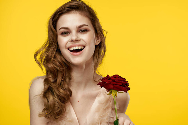素晴らしいです女の子とともに赤いバラ上の黄色の背景トリミングされたビューの感情モデル - 写真・画像
