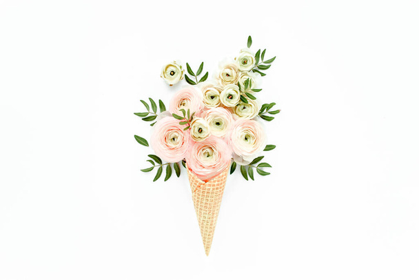 Waffle cone with ranunculus flower bouquet on white background. Flat lay, top view floral background. - Фото, изображение